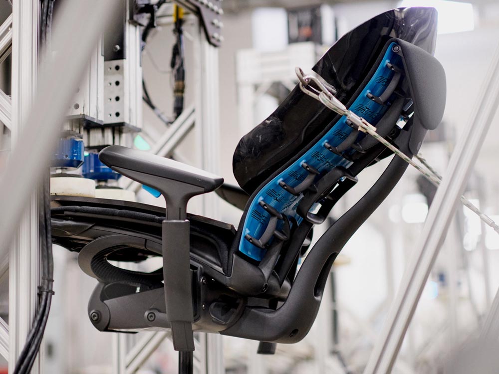 Una silla para videojuegos Embody mostrada desde el lateral en una máquina de ensayos en el centro de fabricación de Herman Miller.