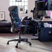 Una silla Herman Miller X Logitech Embody Gaming Chair en azul Cyan como parte de una configuración de juego.